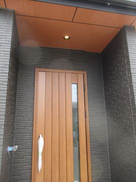 木目の軒天が黒色に映える玄関です。
玄関は断熱ドア。
地球に優しく、防犯性も備えた「YKK AP　VENATO D30」を
採用しています。