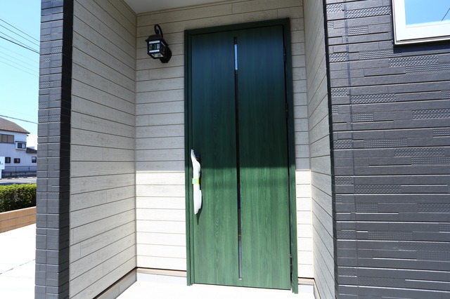 グリーンの玄関ドアが特徴的な家